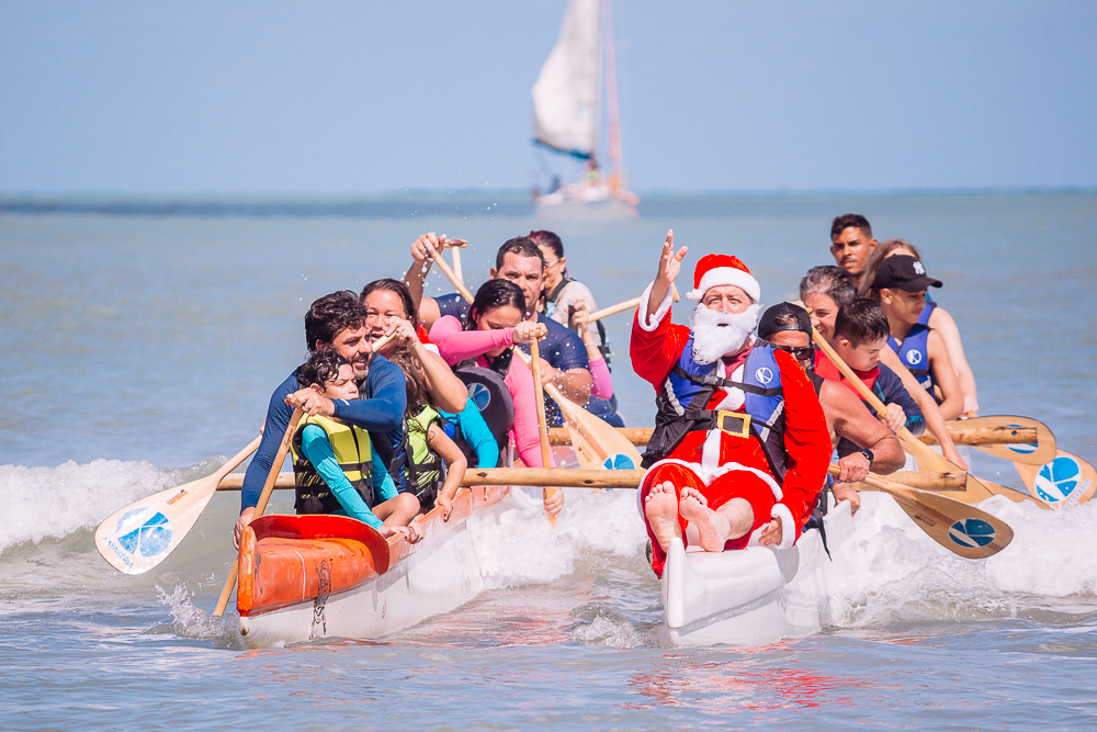 Canoa havaiana adaptada com participantes e voluntários remando juntos